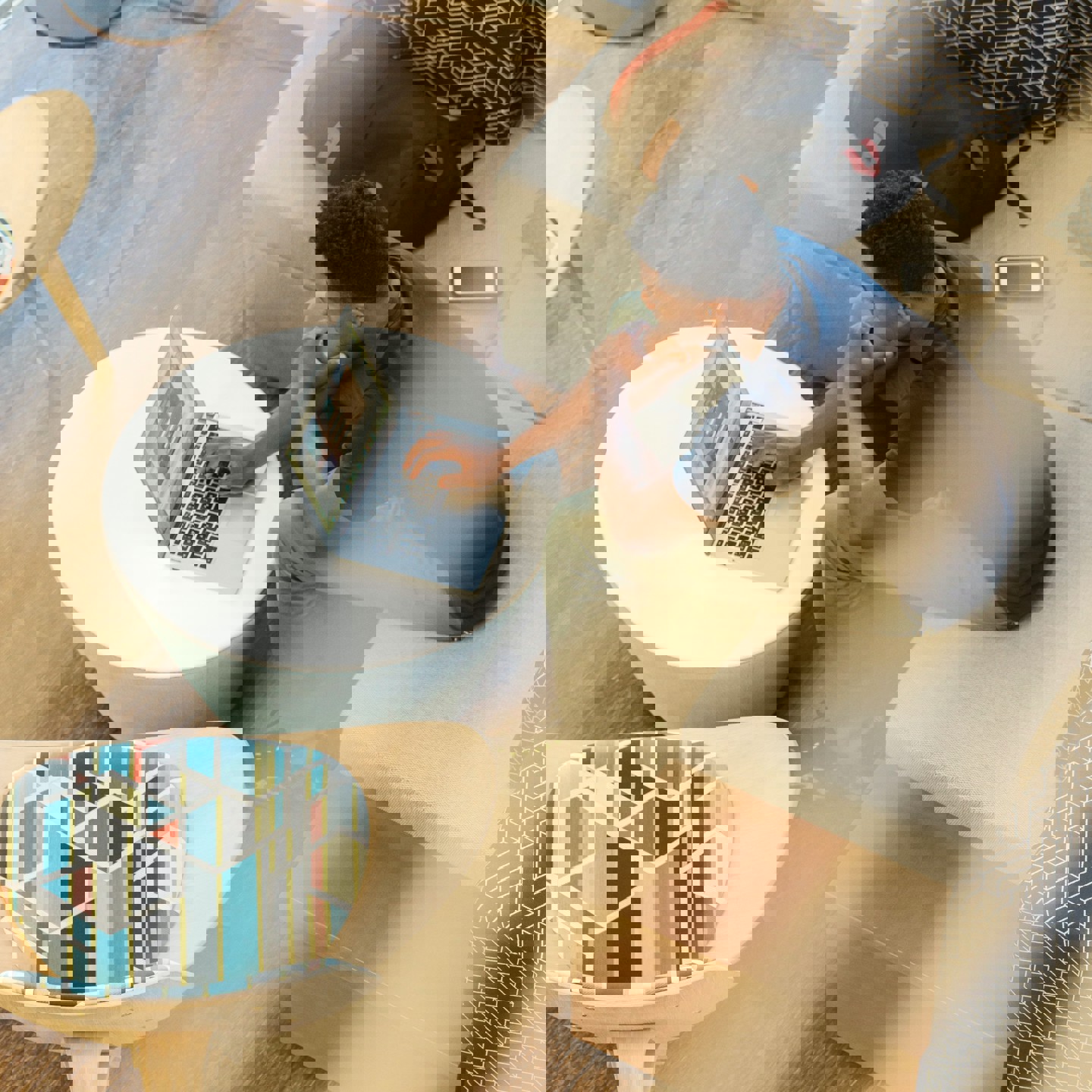 A shot through a 2nd floor interior window of a man on his laptop