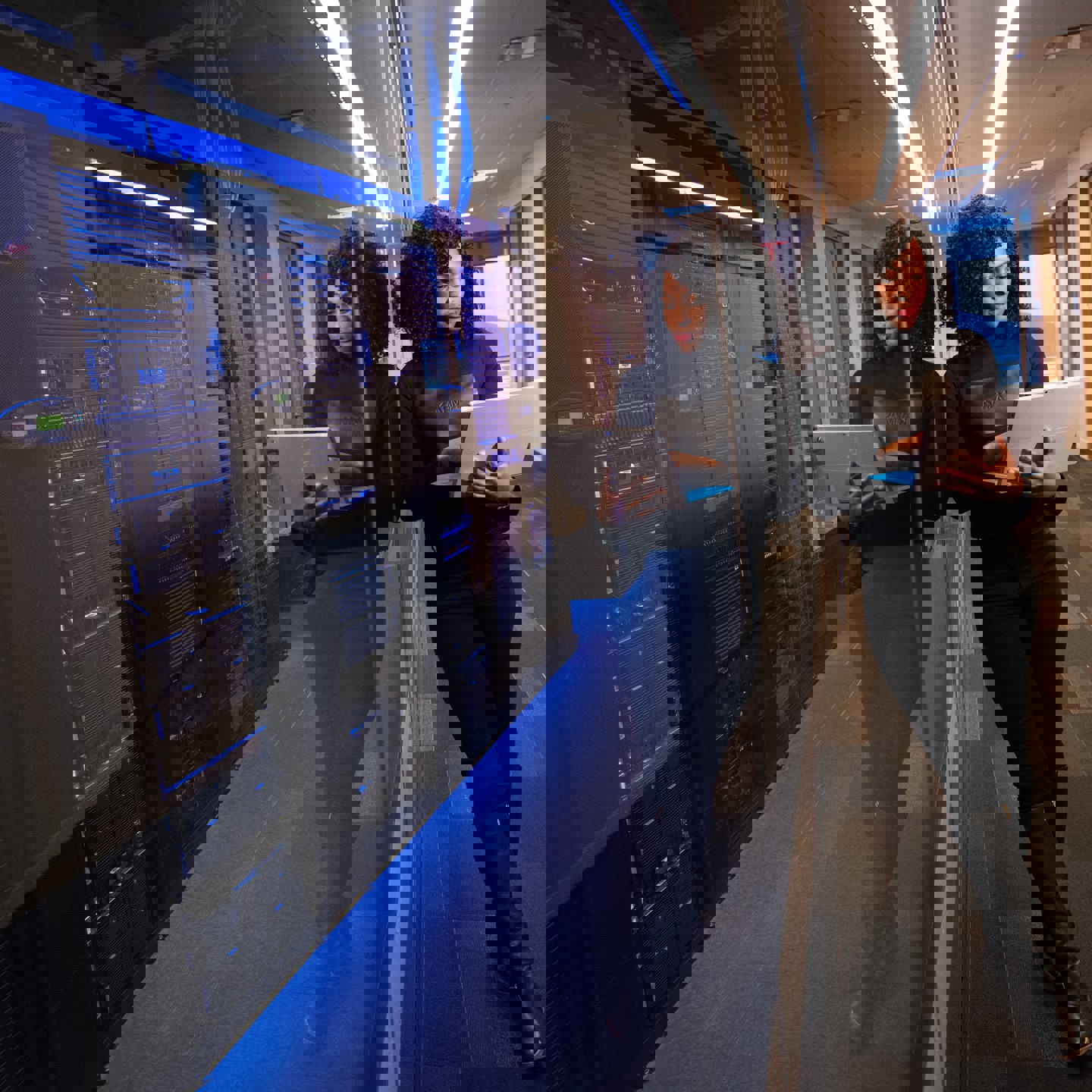 Women viewing laptop in front of serverbanks